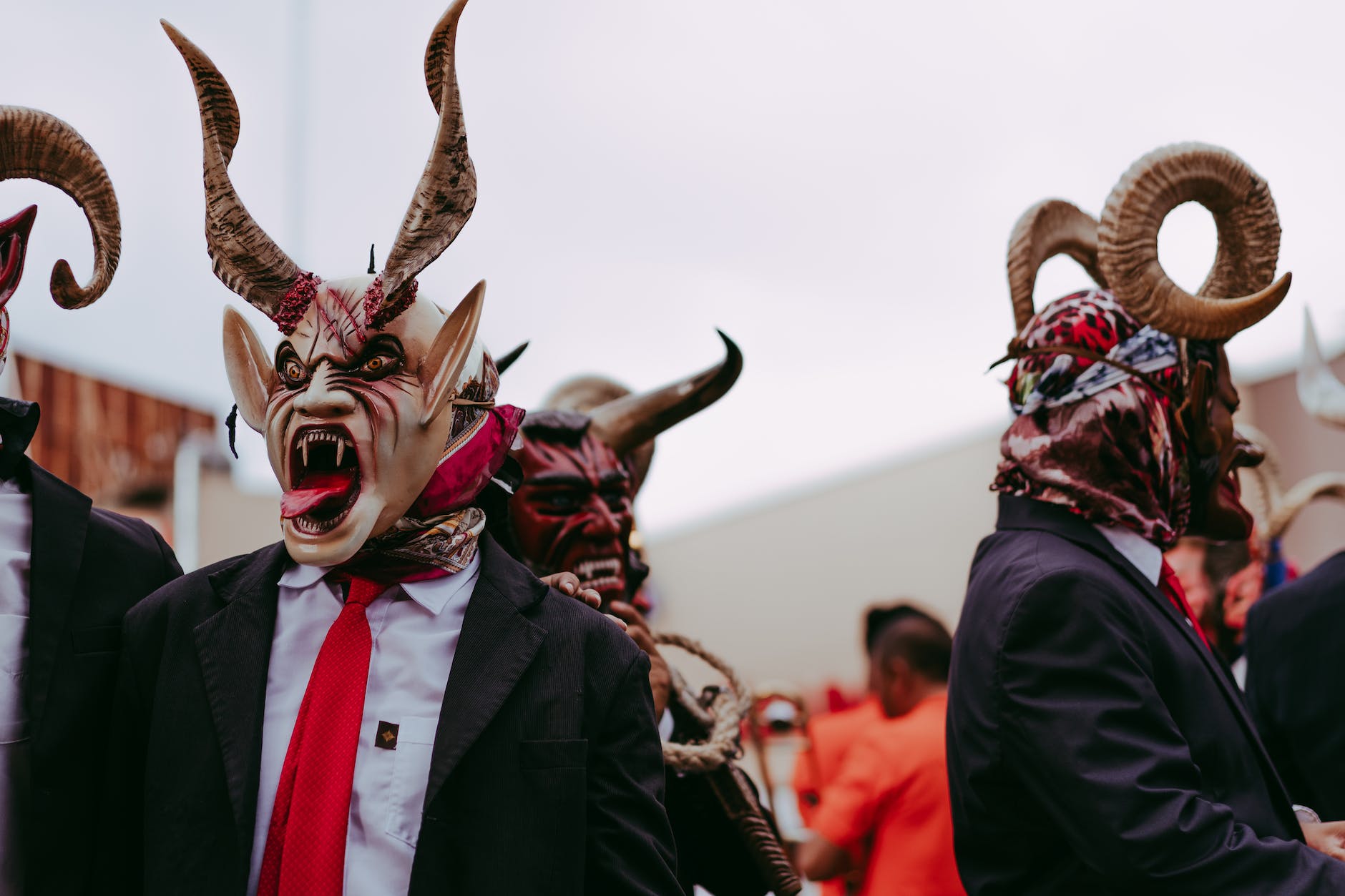 people wearing devil masks dancing